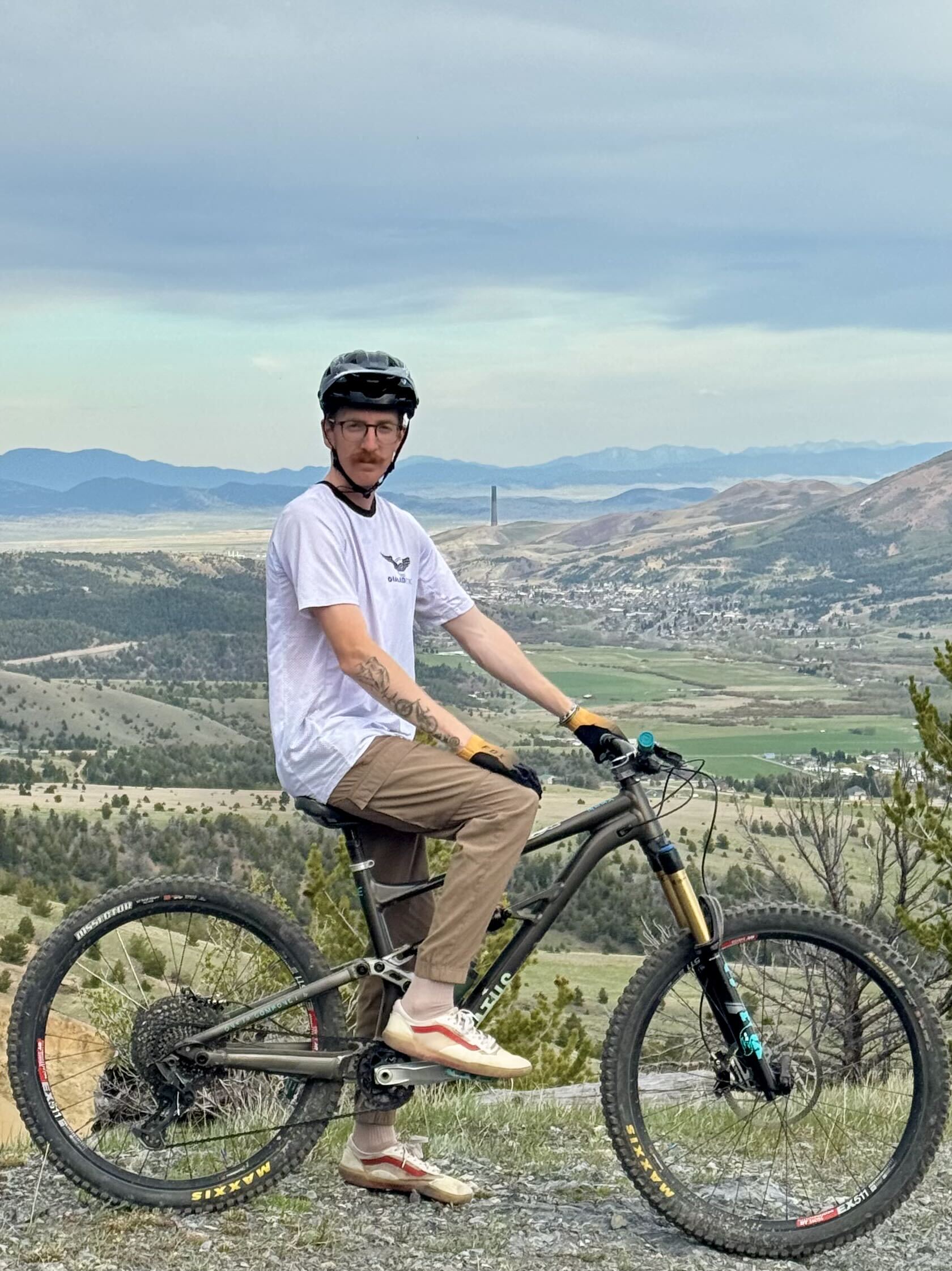 Coach Brooks Richardson on his mountain bike with mountains in the background