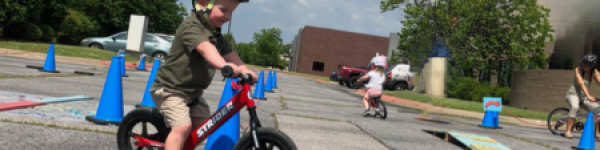 child riding a balance bike in a bike class