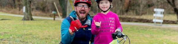 Girl biking with bicycle coach
